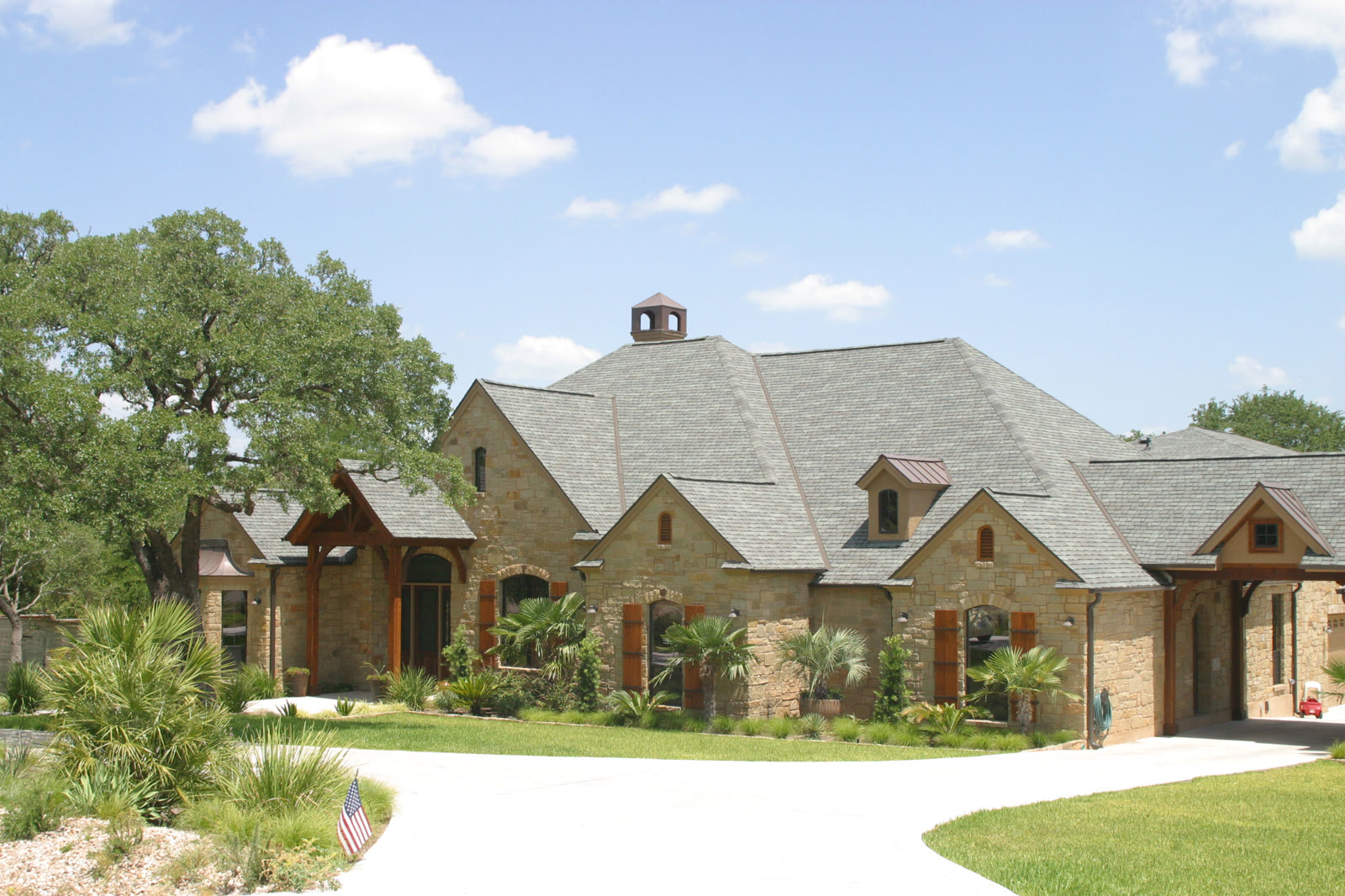 Hill Country home with a copper-capped cupola accenting a dimensional shingle roof