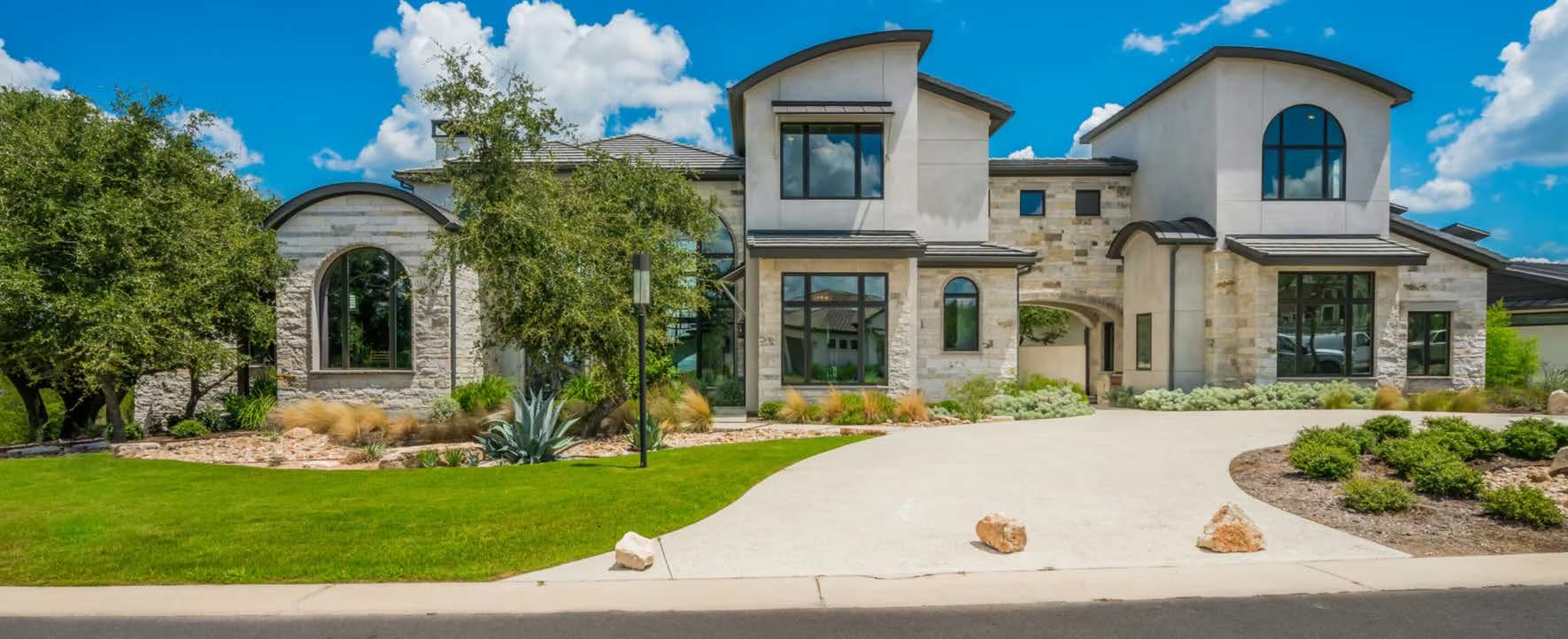 Contemporary Hill Country home with a dark standing-seam metal roof