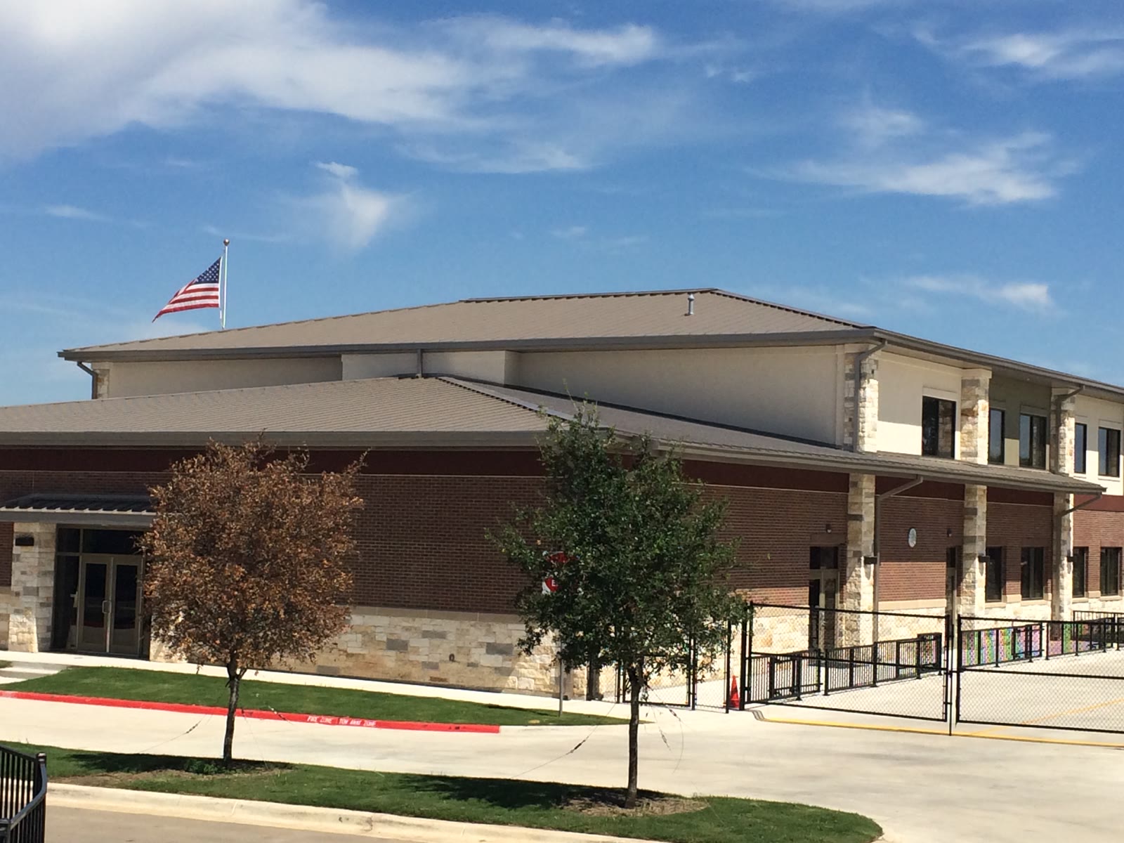 Standing-seam metal roof over a school fieldhouse, aerial view