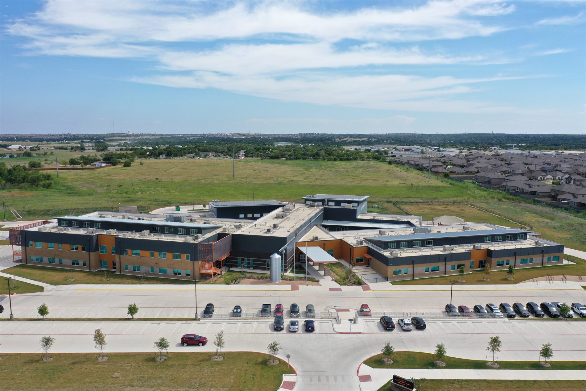 Elementary school roof from the air, showing low-slope membrane and standing-seam sections