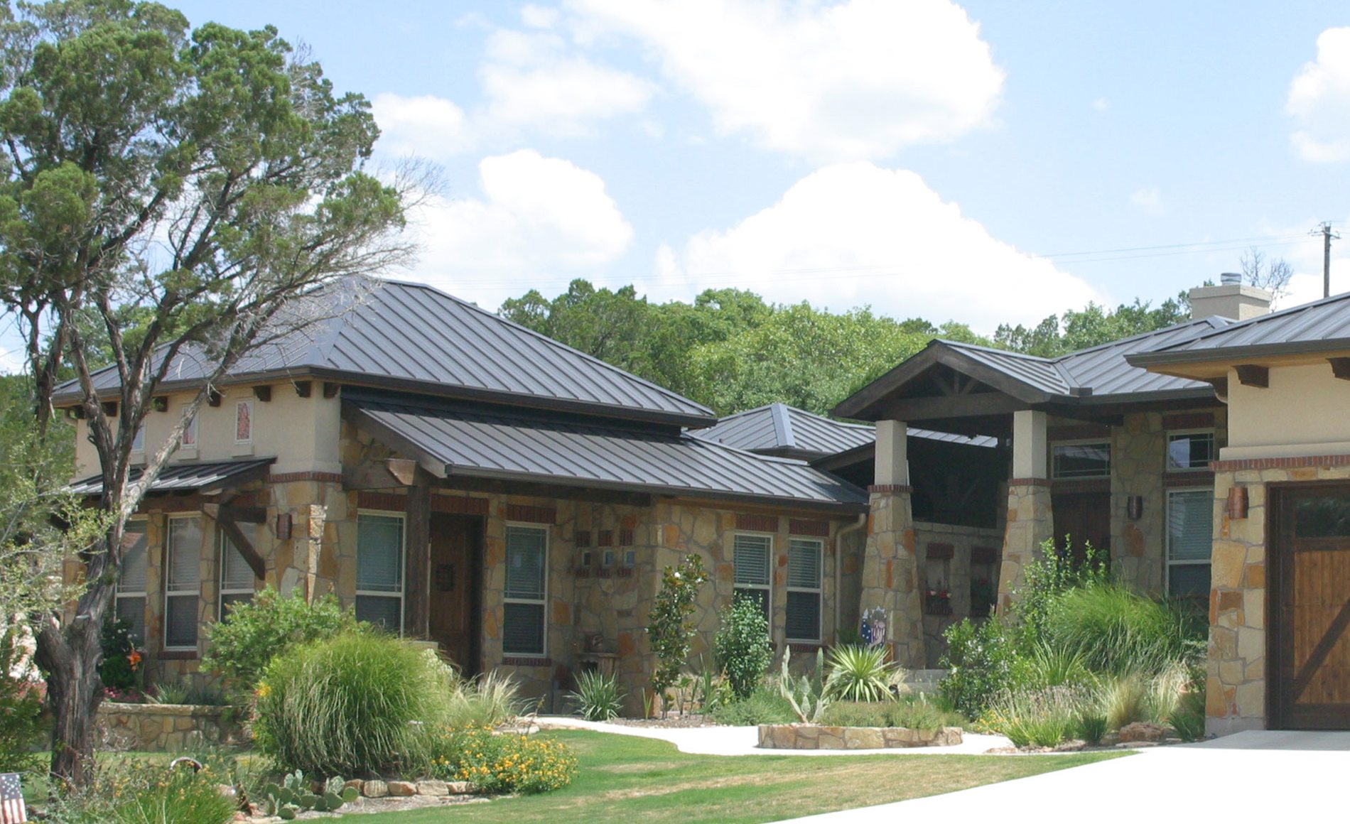 Low-pitch standing-seam metal roof over a porch and porte-cochère