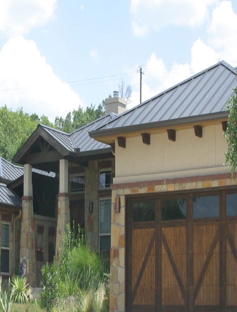Dark standing-seam metal roof over a stone-and-stucco home