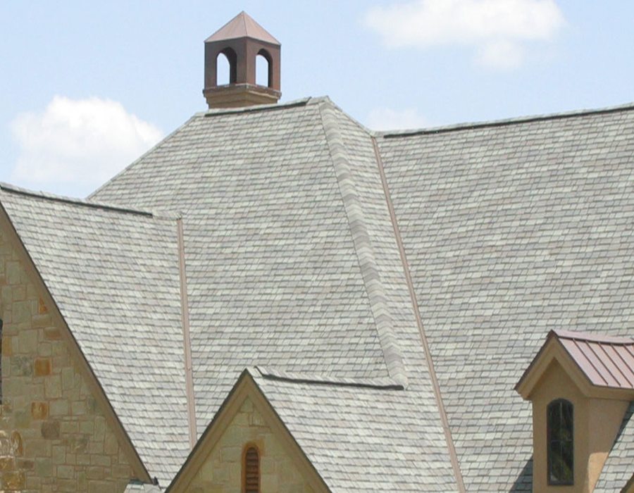 Close view of grey slate coursing meeting a copper cupola