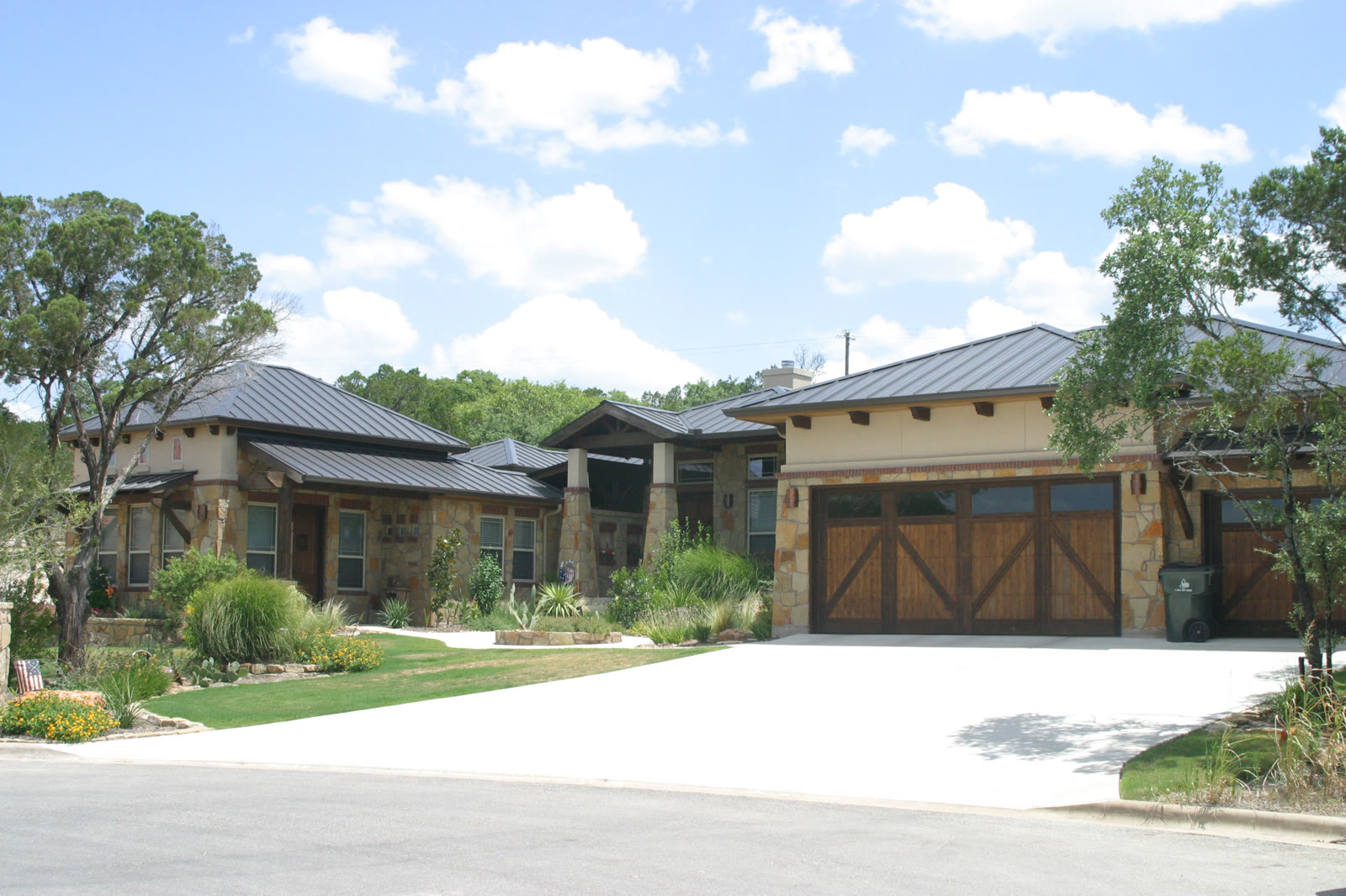 Stone and standing-seam metal roof over a two-story Hill Country home