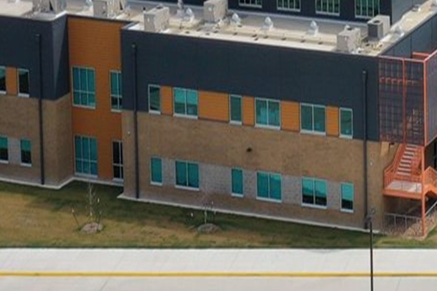 Orange and charcoal metal wall panel cladding on a school facade